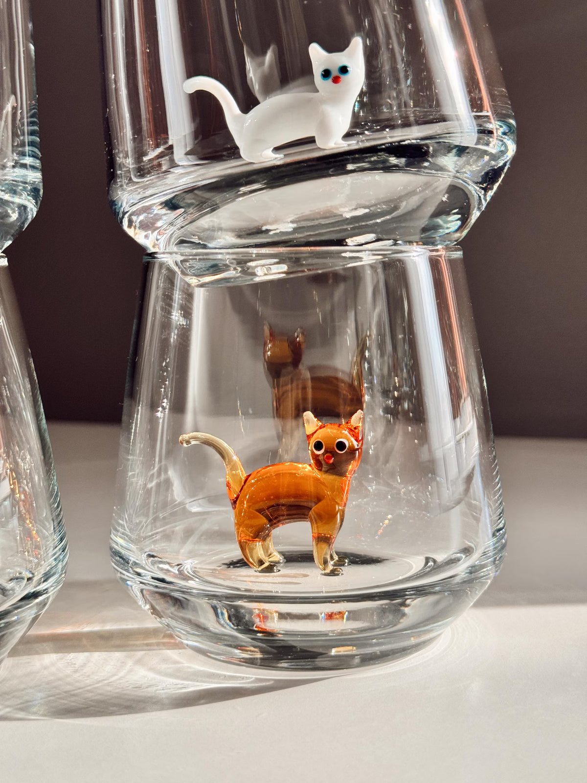 Close view of the handcrafted cat character inside the clear glass cup