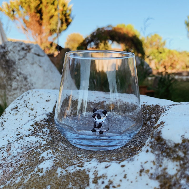 Panda figurine water glass photographed on a white stone