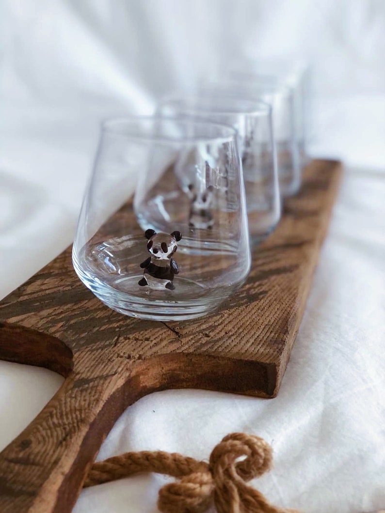 Set of four handmade panda figurine glasses on a wooden tray