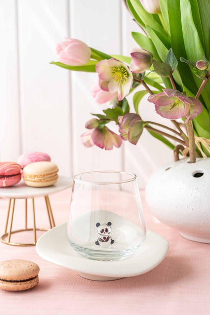 Clear panda figurine tumbler on a white saucer