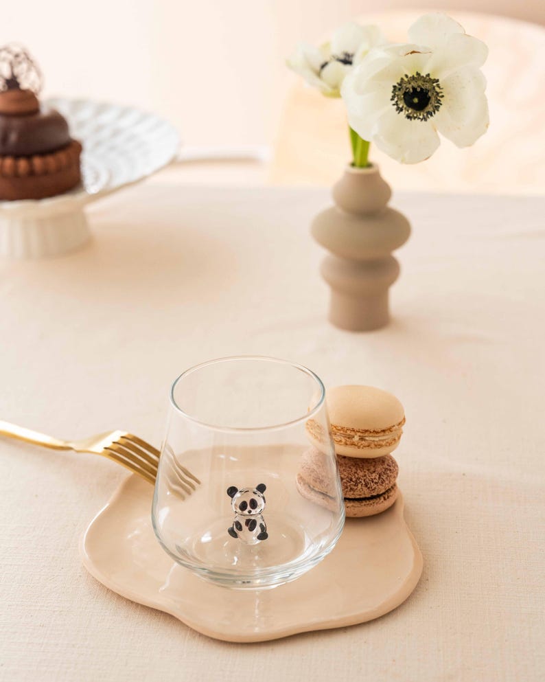 Cute panda glass arranged with a beige saucer and macarons