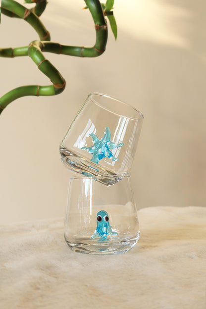 Blue shark figurine inside a clear shot glass