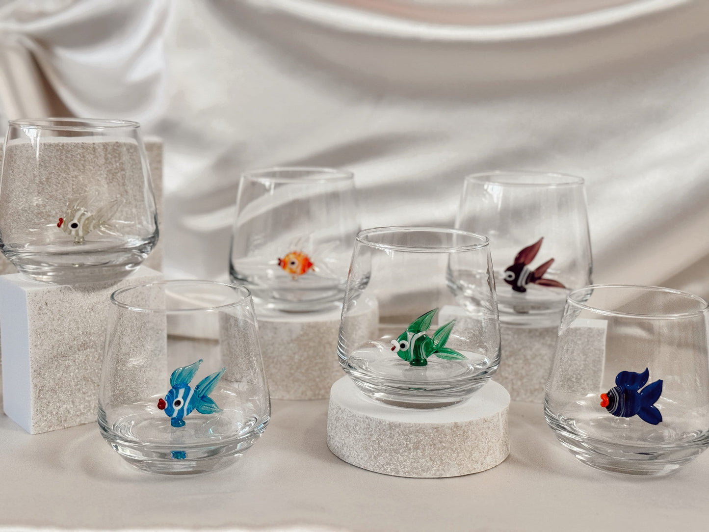 Green fish figurine inside a clear handmade stemless wine glass