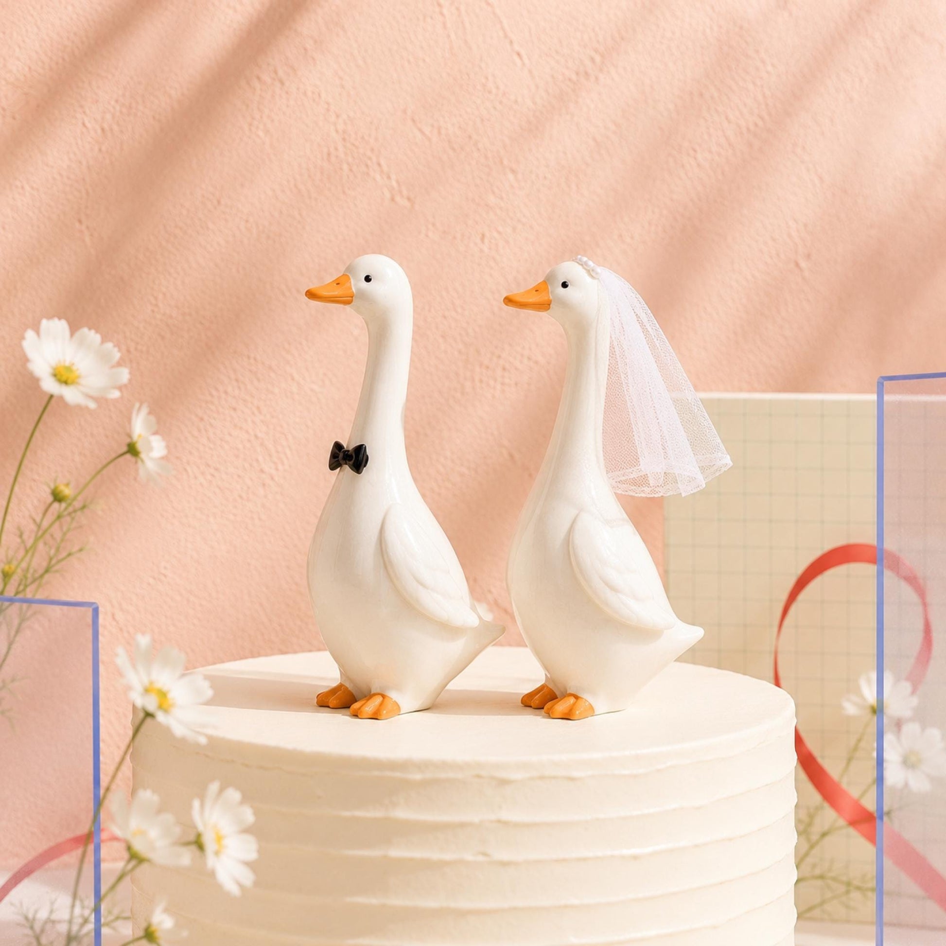 Goose bride and groom figurines displayed on a wedding cake