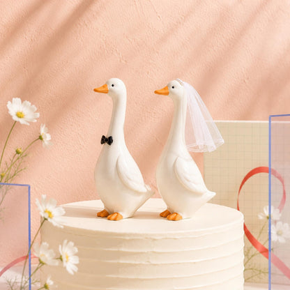 Goose bride and groom figurines displayed on a wedding cake