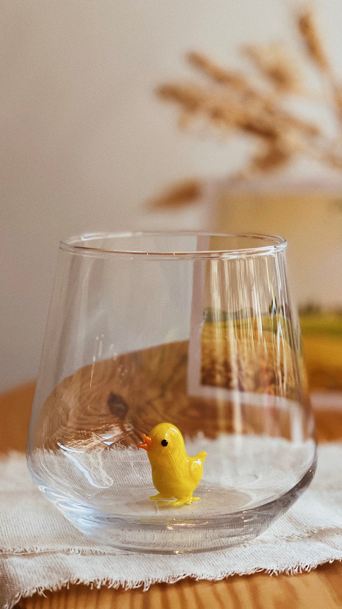 Handmade chick figurine art glass shown upright on a neutral background
