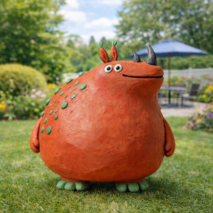 Orange handmade clay monster figurine with green spots and dark horns