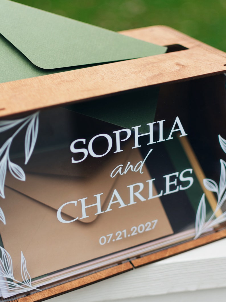 Clear acrylic front wedding card box displayed with cards and gifts sign